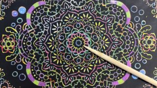 ダイソーの曼荼羅スクラッチアートを削っている途中の写真。少しずつ模様が浮かび上がり、無心で作業できるおうち時間の様子