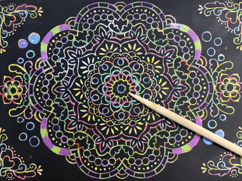 ダイソーの曼荼羅スクラッチアートを削っている途中の写真。少しずつ模様が浮かび上がり、無心で作業できるおうち時間の様子