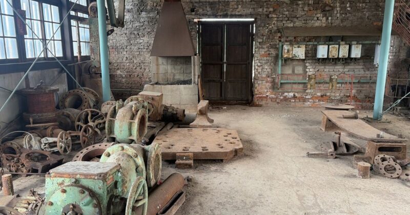 万田坑の床に置かれた錆びたバルブや鉄製部品。無造作に置かれた道具たちが、かつての産業の息吹を感じさせる静かな空間。