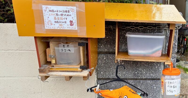 福岡県新宮町相島　港前にあるチャリティー手拭い販売所　募金箱もあり。　2026年7月撮影